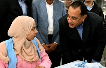  رئيس الوزراء مع عاملة بمصنع «الجيزة للملابس الجاهزة»